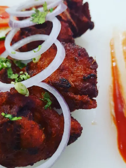 A close look at my B'luru Kebab. This is my take on the classic Bengaluru style chicken kebab, with its distinct red colour and incredibly tender texture. I serve it simply with fresh onion rings to let the flavour of the unique kebab marinade shine through.