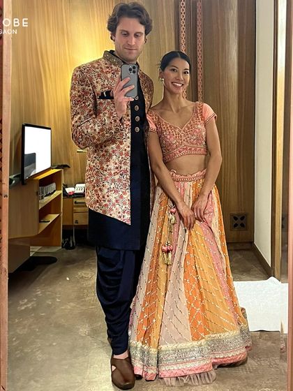 Another great mirror selfie showing off a stylish rental. This floral bandhgala jacket paired with a navy kurta and dhoti pants is a popular choice for its modern and festive vibe.