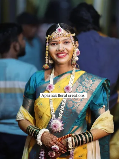 This client is wearing a beautiful set made with jasmine buds and accented with purple flowers for her baby shower, matching her vibrant saree.