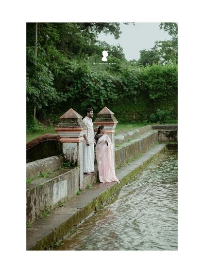 A serene pre-wedding photo by a traditional temple pond. The calm water and classic architecture provide a peaceful and timeless setting.