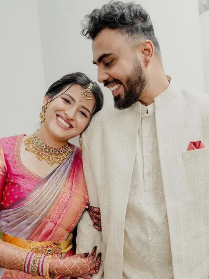A happy couple. The bride wears a beautiful pastel saree with a contrasting pink blouse, featuring delicate embroidery for her engagement ceremony.