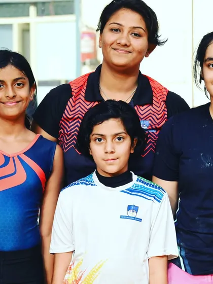 A group of our gymnasts with their coach, showcasing the strong bond we foster at the academy.