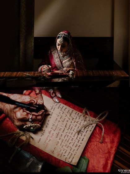A creative shot showing the bride writing a letter to the groom, a personal and emotional touch to their wedding story.