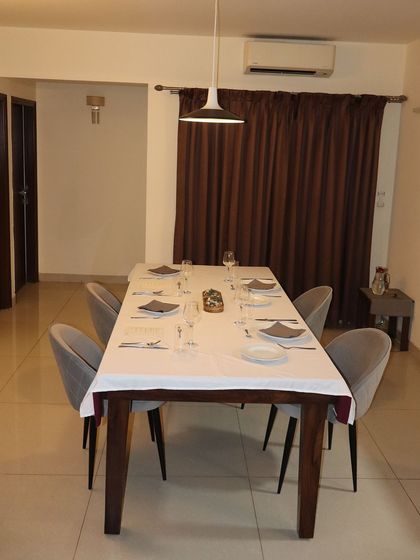 A wide shot of the dining space, ready to welcome guests. The open view into the kitchen allows for an interactive and engaging private dining experience.