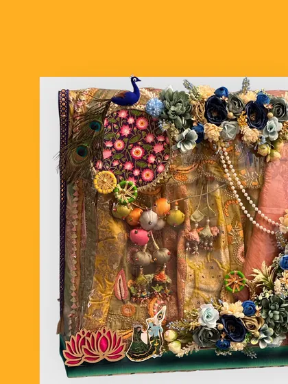 This elaborate trousseau packing for Teej features a full suit decorated with peacock feathers, pearl strings, and a beautiful floral arrangement. It's a perfect way to present a gift to a bride to be.