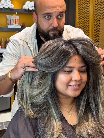 A happy client with her new ash blond hair, a perfect cool-toned transformation.