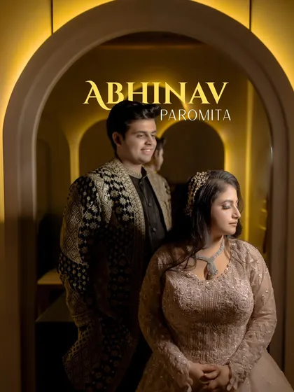 Abhinav and Paromita framed within a warmly lit archway. This portrait from their ring ceremony has a classic, romantic feel, highlighting their regal attire.