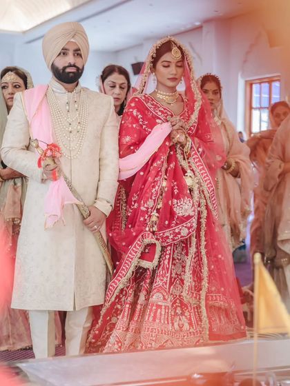 The couple performs the Laavan Pheras, a central part of the Sikh wedding. This shot captures the movement and tradition of the ceremony.