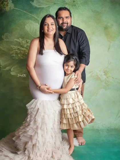 A beautiful family portrait celebrating a new arrival. The older sister to be is so excited to be part of her mom's maternity shoot.