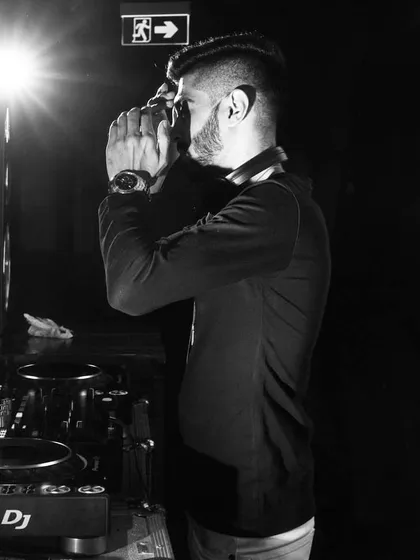 A candid black and white shot of me speaking into the microphone during a set. Whether it's a simple "hands up" or a shout-out to the guests of honor, my mic work is all about enhancing the vibe.