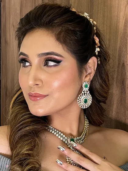 A close-up of the half-up wavy hairstyle, showing the delicate hair accessory used to secure the style. The makeup features a pink smokey eye, adding a touch of drama.
