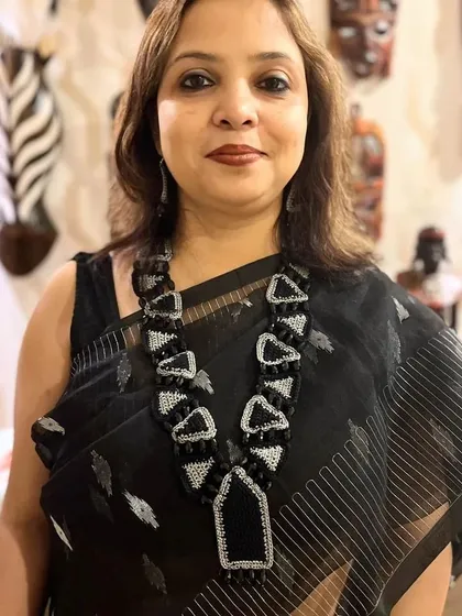 This custom-designed geometric necklace, seen here on a happy patron, is an example of our statement jewellery. We combine crochet with beads and zari to create unique, wearable art that complements your individual style.