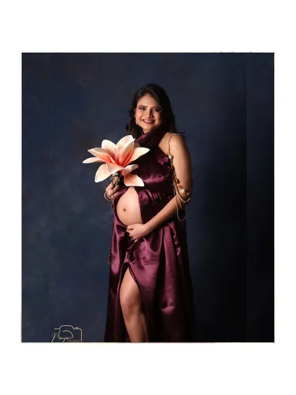 Holding a single large flower, this portrait is artistic and symbolic, representing the new life that is about to bloom.