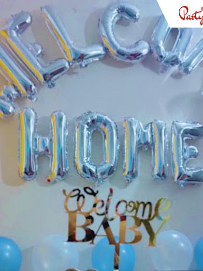 A simple yet heartfelt "Welcome Home" setup. I used silver foil letter balloons and a "Welcome Baby" cake topper prop against a backdrop of blue and white balloons to create a warm welcome for the new arrival.