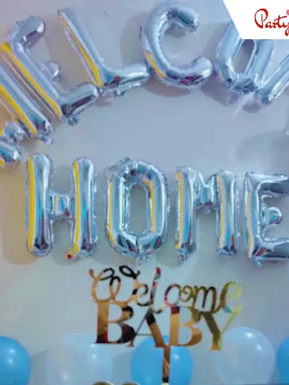 A simple yet heartfelt "Welcome Home" setup. I used silver foil letter balloons and a "Welcome Baby" cake topper prop against a backdrop of blue and white balloons to create a warm welcome for the new arrival.