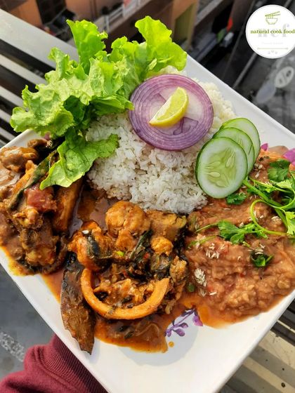 A special platter featuring Sareng (boal fish) curry, a flavorful stink bean eromba, and a local chicken curry.