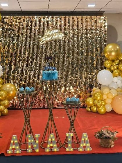 A wide view of the glamorous 13th birthday setup with a gold shimmer wall and marquee numbers.
