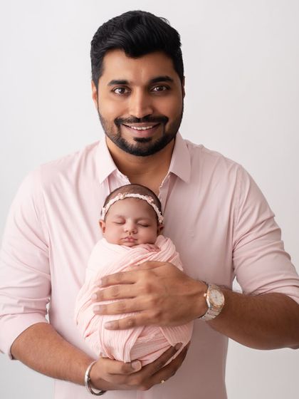 A proud father holding his newborn. This is a portrait he will cherish for the rest of his life.