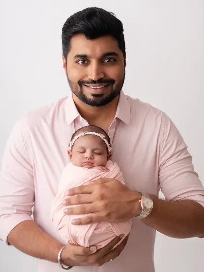 A proud father holding his newborn. This is a portrait he will cherish for the rest of his life.