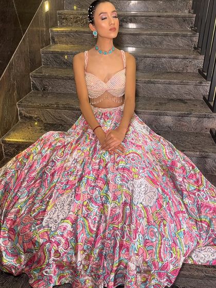 A series showcasing our "soft girl era" lehenga. The printed skirt, pearl-fringed blouse, and sheer embroidered jacket make it a dreamy and feminine choice for a day event.