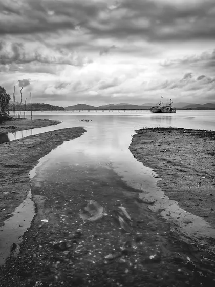 A quiet scene from Gokarna in 2012, showing the Aghanashini river meeting the sea. The black and white conversion gives it a classic, documentary feel, reflecting a time before it became a major tourist spot.