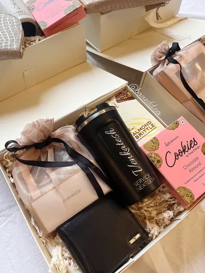 A premium birthday gift box for an employee at Service Nextgen. It includes a personalized shaker, a wallet, luxury bath products, and gourmet treats, showing deep appreciation.