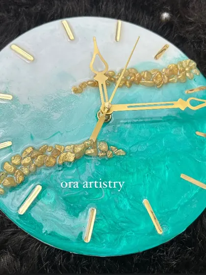 A mini resin clock with a lovely teal and white design, accented with a band of gold stones.