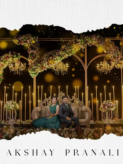A grand reception stage portrait, where the couple is seated amidst opulent floral decor and candlelight.