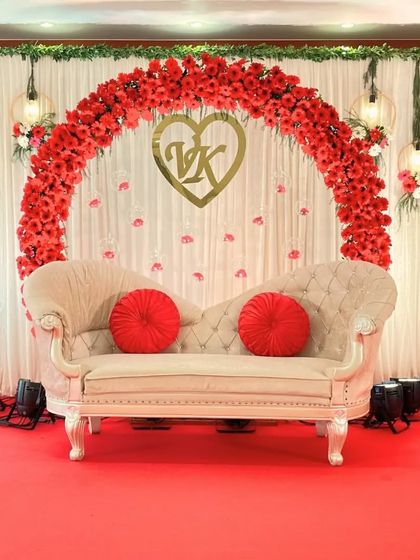 A stunning circular arch made entirely of red flowers creates a powerful and romantic statement, personalized with the couple's initials in a golden heart.
