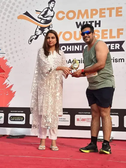 A member receiving a trophy on stage. We are proud to have podium finishers in our group.