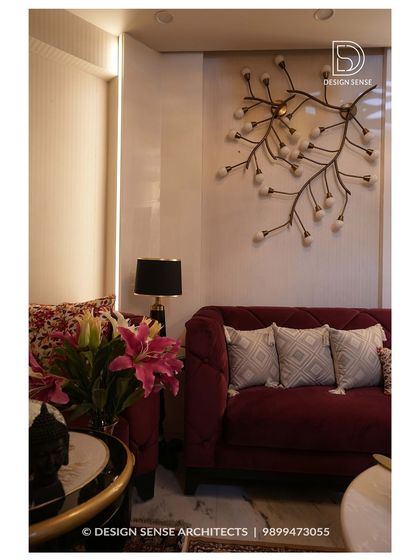 A closer look at the details in our "5-star hotel" project, highlighting the custom branch-like wall light fixture and the plush, deep-red velvet sofa that adds a pop of color and luxury.
