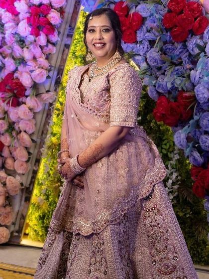 A full-length shot against a floral backdrop. The soft pink lehenga and my makeup service make for a stunning combination.