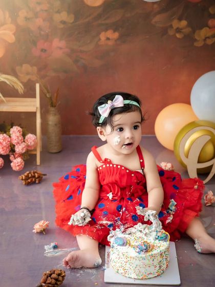 A sweet, messy portrait of a baby girl enjoying her first birthday cake. These are the moments of pure, simple joy.