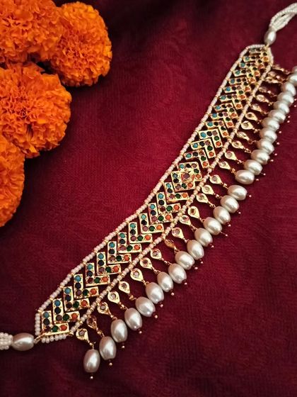 The 'बेला' (Bela) Hyderabadi Jadau necklace. This piece features intricate navratan-style stonework and pearl drops, making it a colourful and versatile choker for any ethnic outfit.