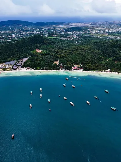 Aerials from Vietnam. A wide shot of the coastline, showing the beautiful beaches and lush green hills of this diverse country.