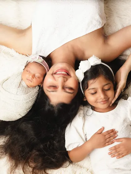 A creative overhead shot of a mother lying with her two daughters. This pose is playful and unique, creating a beautiful portrait of her life with her girls.