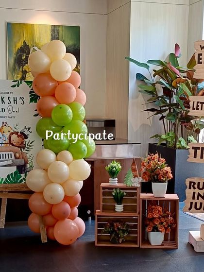 The welcome area for Ekaksh's safari party featured a personalized sign, rustic wooden crates, and a fun directional signpost to guide guests to the jungle adventure.