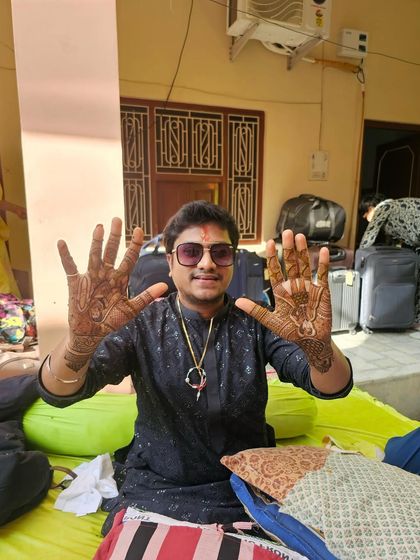 The groom showing both his hands, fully decorated with henna. This is a classic look for any groom who wants to fully embrace the traditions of a big Indian wedding.