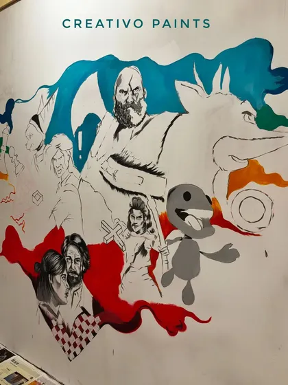The next step is blocking in the basic shapes and colors. This image shows the gaming mural as the initial layers of paint are being applied over the sketch.