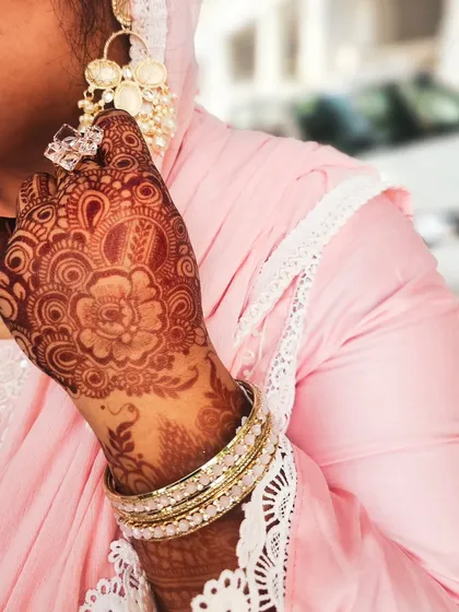 The rich stain on the palm, beautifully accessorized with elegant jewelry.