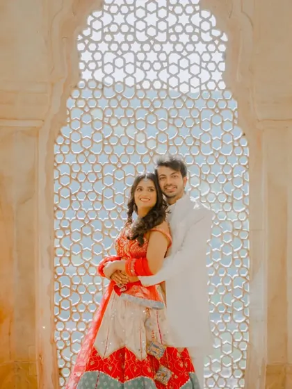 Our photography is about finding unique perspectives. Here, we used the intricate marble latticework, or 'jali', to frame the couple, creating a beautiful play of light and shadow that adds an artistic touch to their pre-wedding portraits.
