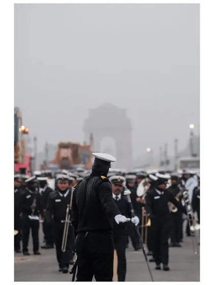 The Indian Navy contingent marches towards India Gate, which is faintly visible in the morning fog during parade rehearsals.