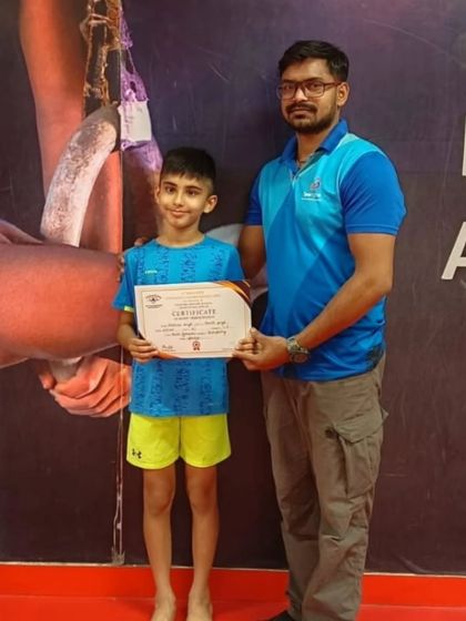 A proud student and coach pose with a new certificate of achievement.