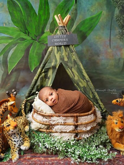 Another view of our little camper. This wide-eyed newborn is peeking out from his basket, surrounded by his jungle animal friends.