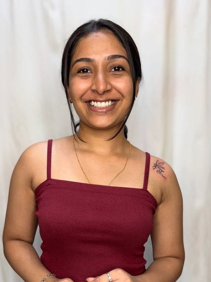 A happy client smiling after getting her small fairy tattoo.