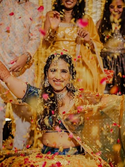 The bride enjoying the moment as her friends and family shower her with flower petals.