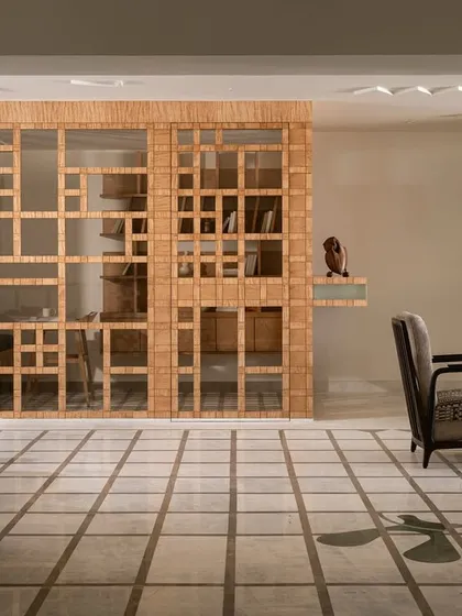 This foyer in our 'Gingham Dreams' project features a marble grid floor that leads to the bedrooms. The space is bookended by a study and a custom veneer console, with geometric motifs on the ceiling mirroring the floor pattern.