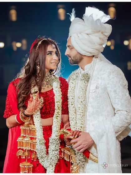 A classic wedding portrait of the couple sharing a look after their Varmala ceremony, their smiles reflecting their happiness.