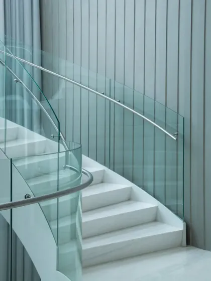 Images from the "Shades of White" project, focusing on how minimalism, light, and subtle details like a curved glass railing or a pop of color from a chair can create a powerful architectural statement.