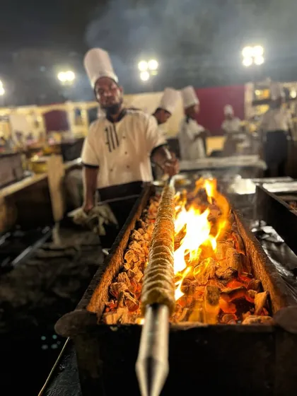 My chef proudly presents a perfectly grilled skewer of kebabs, fresh off the fire and ready to be enjoyed.